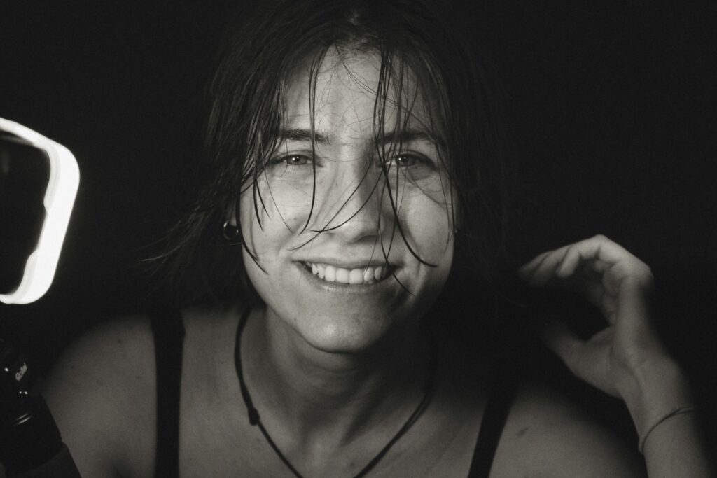 Black and white close-up of a smiling person with a natural, makeup-free look, symbolizing clean, chemical-free skincare